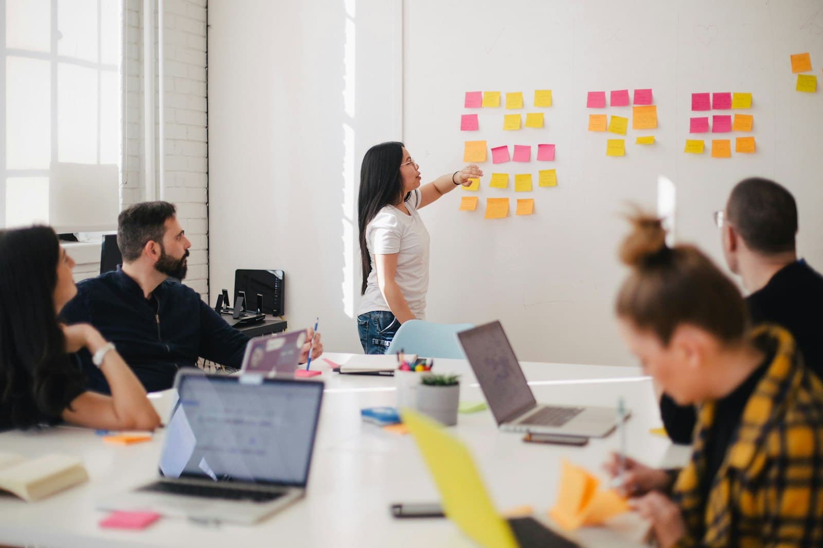 Consultants running a strategy workshop with sticky notes on a whiteboard